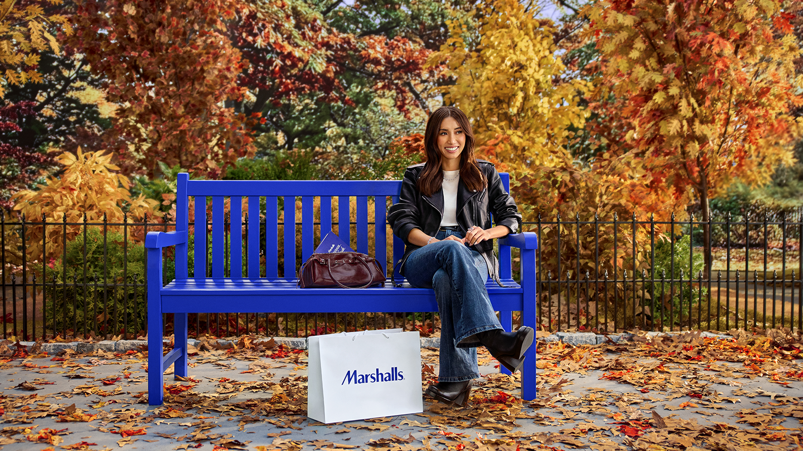 brenda song sitting on a bench in the fall reading the marshalls fall fashion guide 