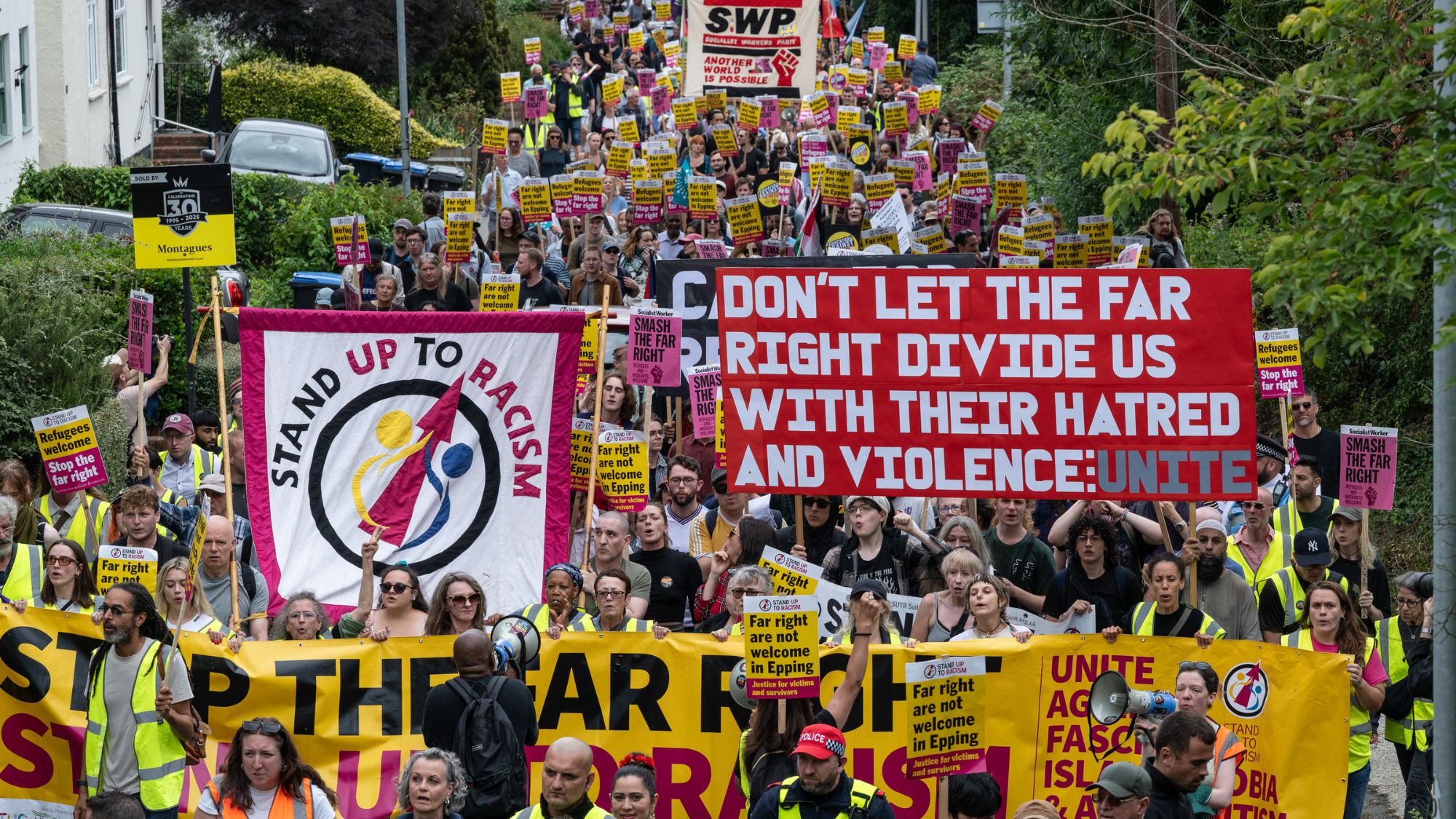 EPPING, ENGLAND - JULY 27: Stand Up To Racism and local trade unions march through Epping to protest the presence of the far right on anti migrant protests on July 27, 2025 in Epping, England. Anti-migrant protesters , as well as counter-protesters, have organised rallies in Epping near the Bell Hotel, which is being used as migrant accommodation. The far-right activist Tommy Robinson told his social media followers earlier this week that he would also join the demonstrations, although he did not attend. A series of protests have taken place here following the arrest of an asylum seeker on suspicion of alleged sexual assaults in the town. (Photo by Guy Smallman/Getty Images)