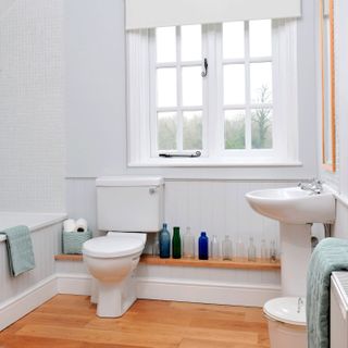 bathroom with wash basin and window with commode
