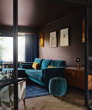 colors that go with teal, brown and teal living room with brown walls and ceiling, teal couch, pouf and footstool, wooden floor
