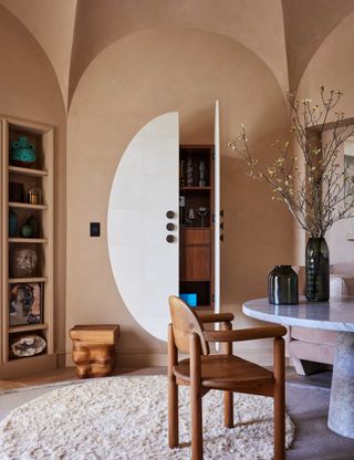 terracotta lime wash walls with bar hidden behiind round white doors in wall cavity
