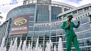 A Riddler cosplayer poses in front of WonderCon sign at the Anaheim Convention Center