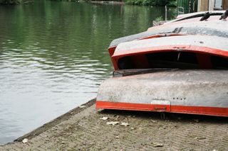 Close up of boats overturned next to a lake