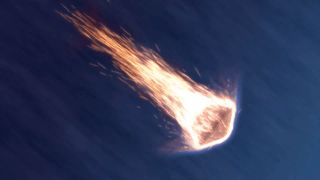 a space capsule descends the atmosphere surrounded by hot flaming embers