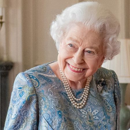 Queen Elizabeth wearing a blue paisley dress and pearls