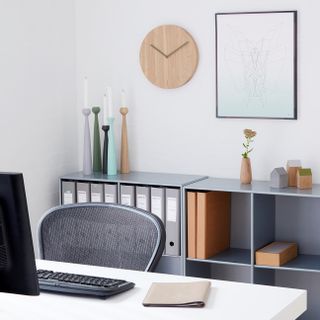 a corner work area with a desk and organised, minimalist filing system
