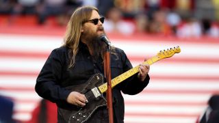 Country singer Chris Stapleton performs the national anthem against an American flag background ahead of his performance at the CMA Awards 2023.