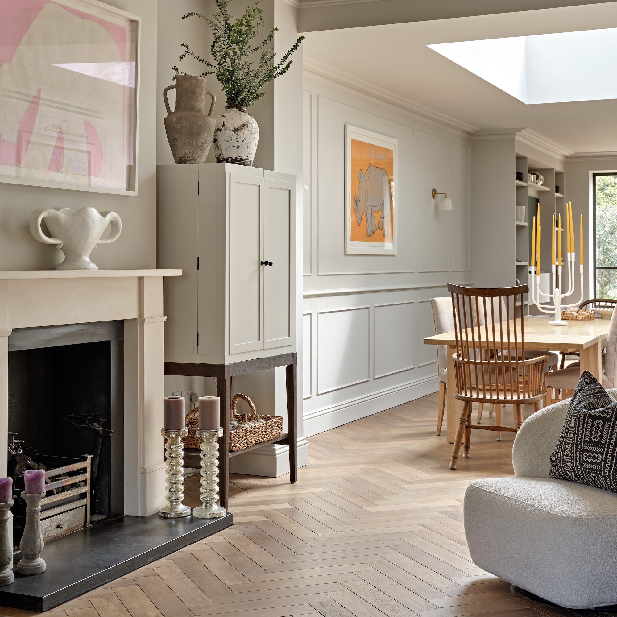 open-plan ground floor in extended Edwardian house wiht fireplace and sitting area with dining area with skylight beyond