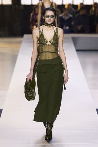 Woman in green outfit on Gucci runway