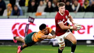 British and Irish Lions' Huw Jones (R) runs away from Australia's Len Ikitau during the second rugby Test match at the Melbourne Cricket Ground (MCG) on July 26, 2025.