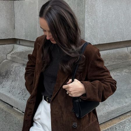 Liv Perez wearing a brown suede Madewell x Alexa Chung trench coat with a black shirt and white jeans.