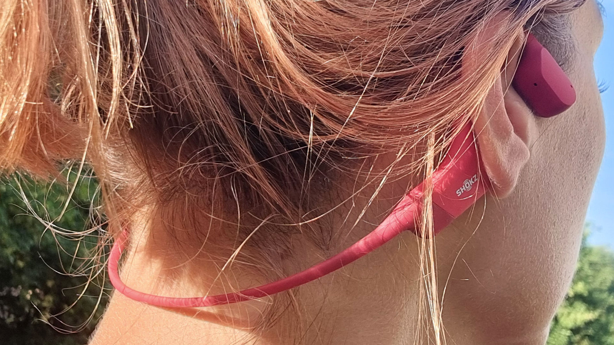 A close-up picture of our reviewer testing the Shokz Openrun bone conduction headphones