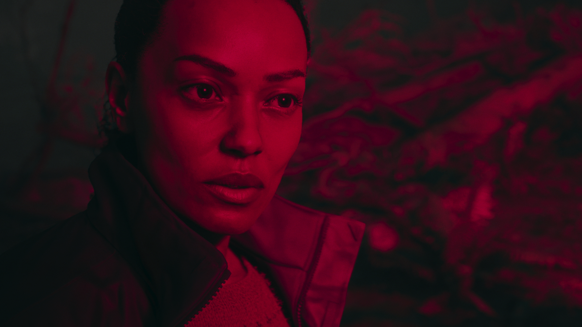 Saga Anderson bathed in red light in Alan Wake 2.