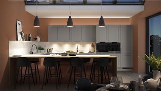 Grey and white kitchen with terracotta walls shot at night to show the ambient lighting