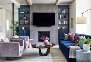 Living room with lavender armchairs and dark blue sofa and walls