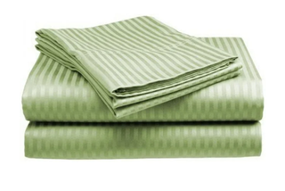 a set of green cotton bedding folded into a pile