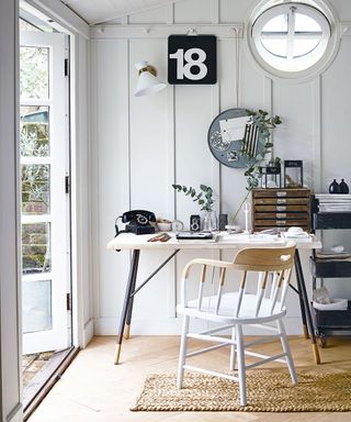 home office shed with wooden chair table and white light