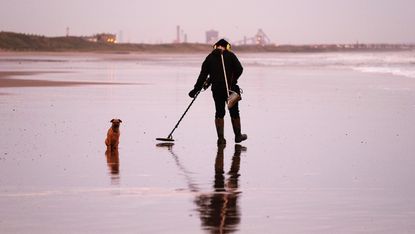A man seeks treasure on a UK beach