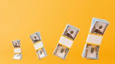 wads of 100 dollar bills on yellow background