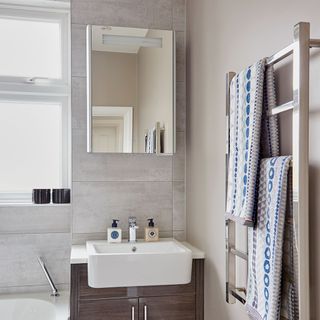 bathroom with mirror on wall and white washbasin