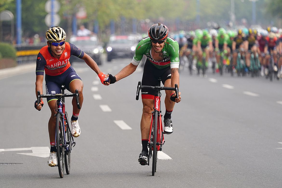 Daniel Oss and Wang Meiyin shake hands after a spell in the breakaway