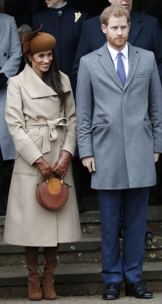 Prince Harry Meghan Markle (L) and Britain's Prince Harry (R) stand together as they wait to see off Britain's Queen Elizabeth II after attending the Royal Family's traditional Christmas Day church service at St Mary Magdalene Church in Sandringham, Norfolk, eastern England, on December 25, 2017