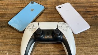 A DualSense controller next to an iPhone and Google Pixel