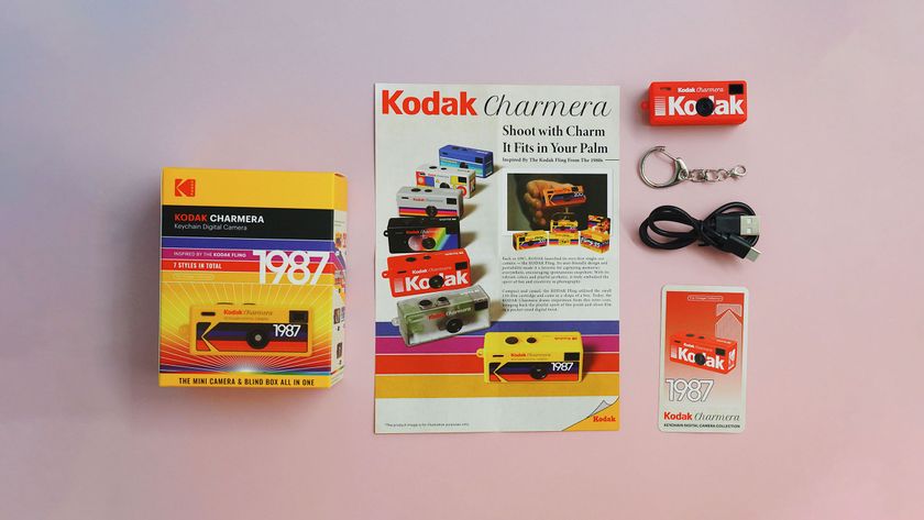Kodak Charmera in package laying on a surface, next to it its manual, followed by a Charmera model, keyring, USB cable, and Vintage collection card