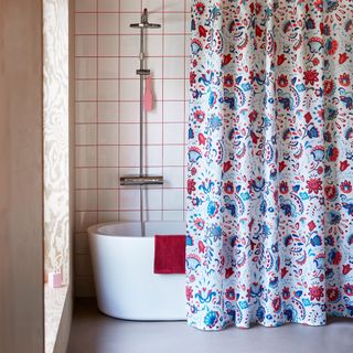white bathroom with floral shower curtain and walled tiles