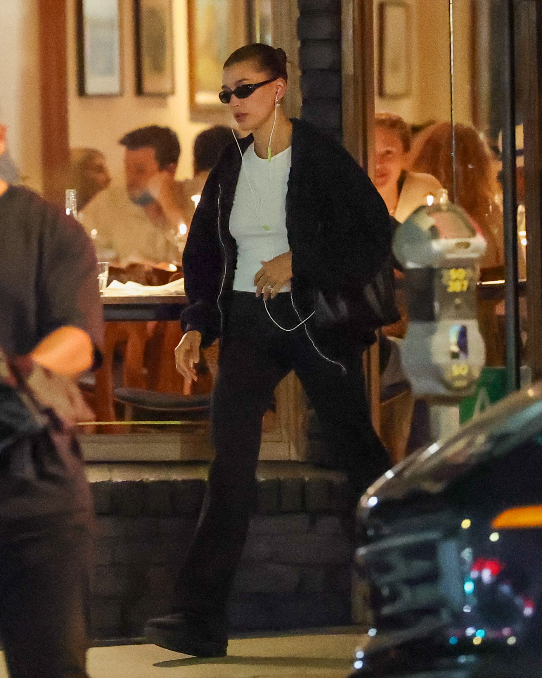 Hailey Bieber wearing chunky black sneakers with sporty yoga pants and a white T-shirt