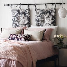 White panelled bedroom with bed with pink and patterned bedding