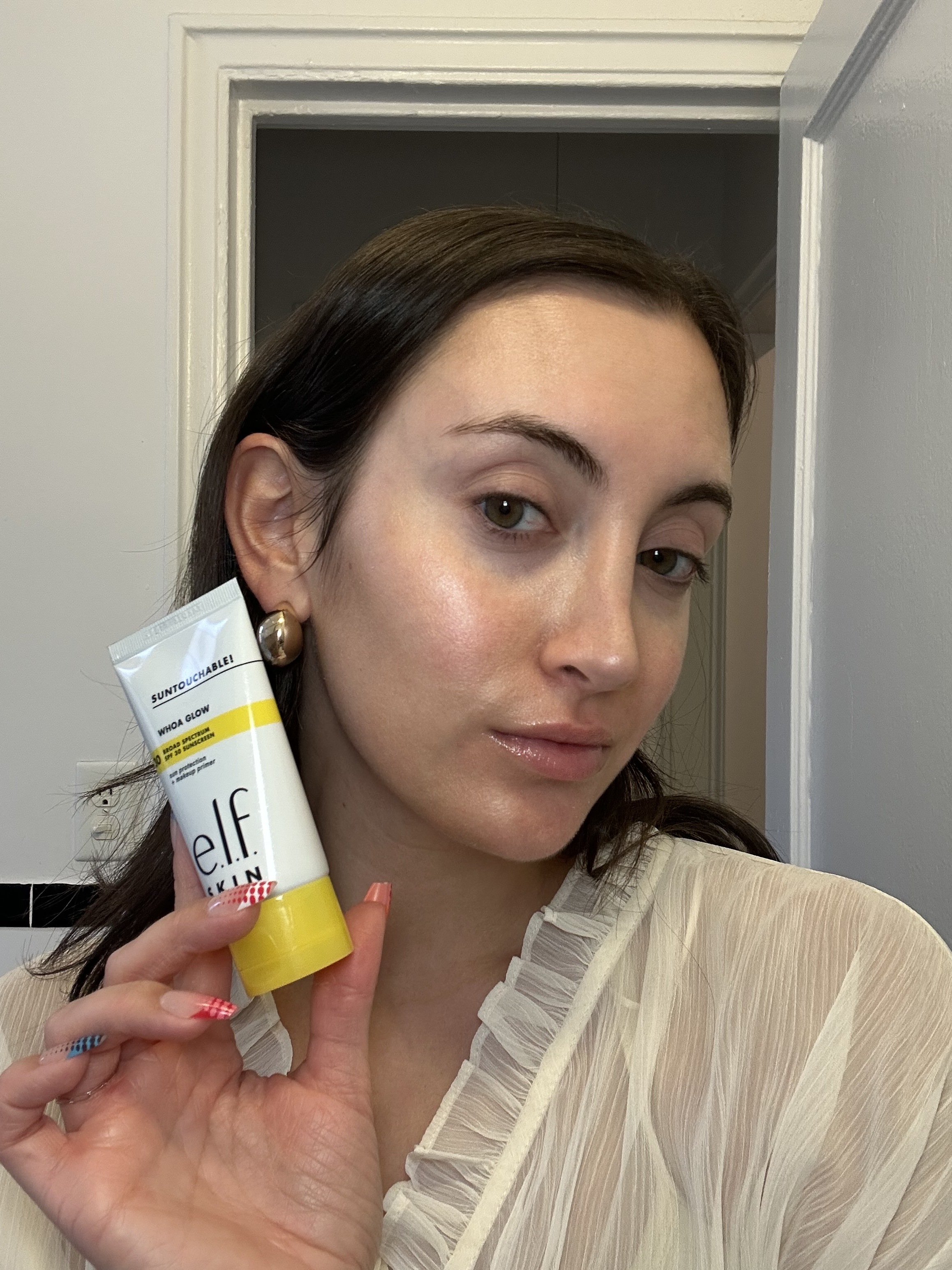Associate beauty editor Alyssa Brascia holding a drugstore primer.