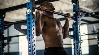 Man performing pull-up in gym