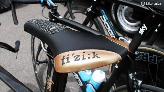 Wiggins sits atop a gold coloured Fizik Ares TT saddle