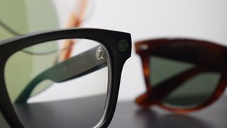 Photograph of Ray-Ban Meta smart glasses with vintage Ray-Ban sunglasses in the background.