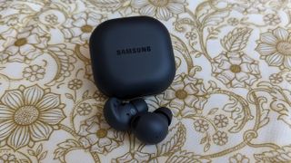The Samsung Galaxy Buds 2 Pro displayed atop a white and gold fabric cloth