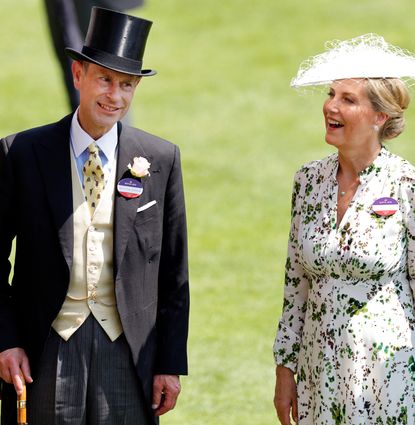 Duchess Sophie wearing a white hat and floral dress and Prince Edward in a top hat and suit smiling at Royal Ascot
