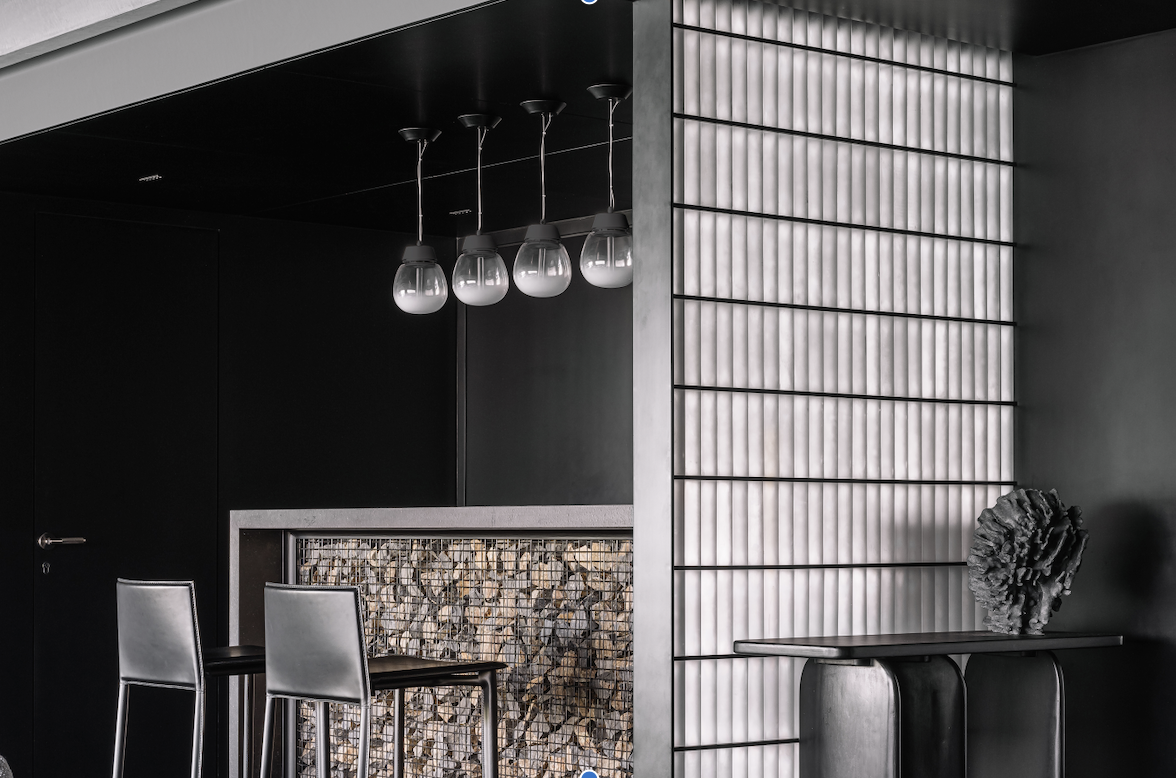 A home bar with black-painted walls, pendant lights above counter, and tall counter chairs, plus a light panel