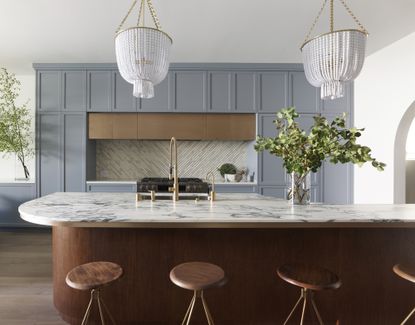 A modern kitchen with a curved marble island countertop