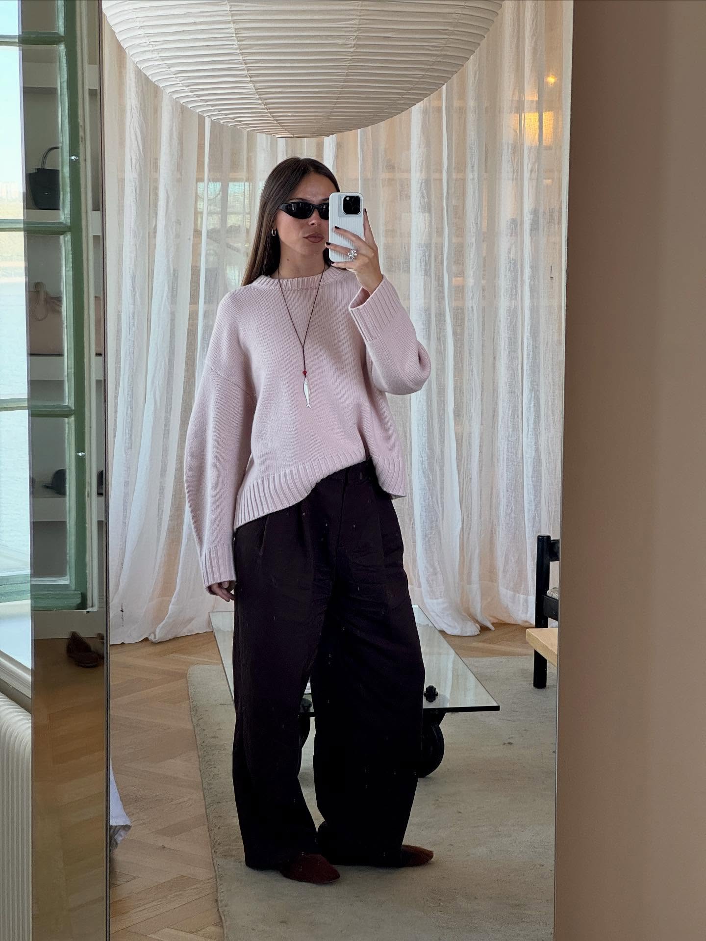 An image of @johannalager wearing a powder pink sweater with black trousers and burgundy shoes.