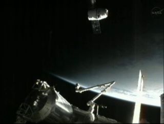 SpaceX's Dragon spacecraft and the International Space Station soar into an orbital sunset while flying over China.