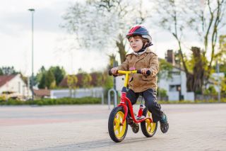 Little toddler boy having fun and riding his bike