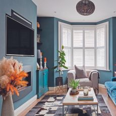 Living room with blue walls and TV recessed into the wall.