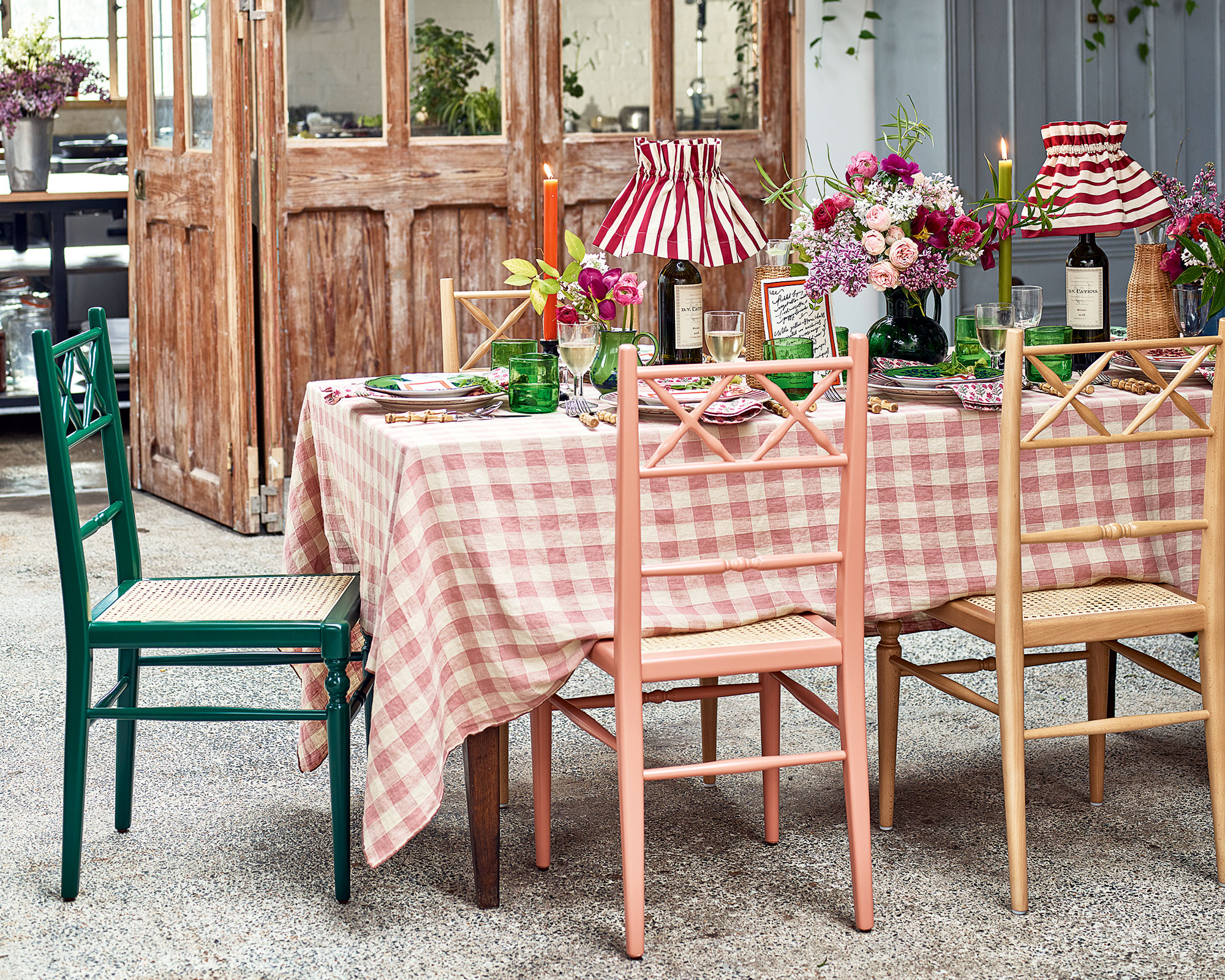 Summer dining table with gingham tablecloth, wood chairs, and green tableware with pendants