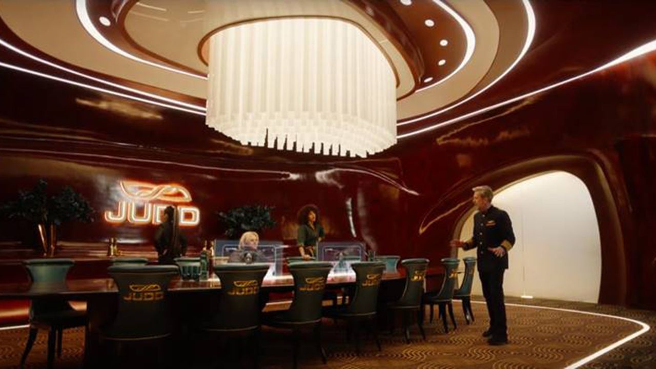The conference room of Avenue 5 features a colossal wood table and paneling.