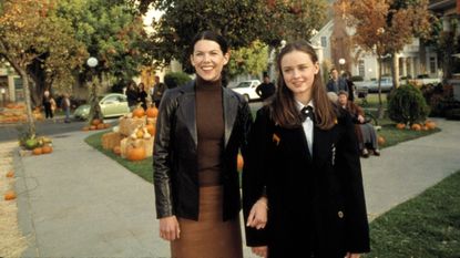 Scene from 'Gilmore Girls', mom and daughter on sidewalk with pumpkins in background