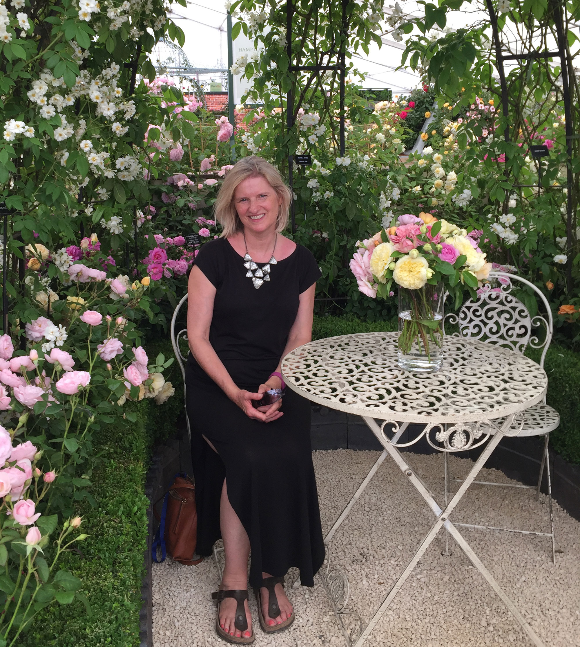 photo of Karen Darlow at Hampton Court flower show with roses and cast iron table
