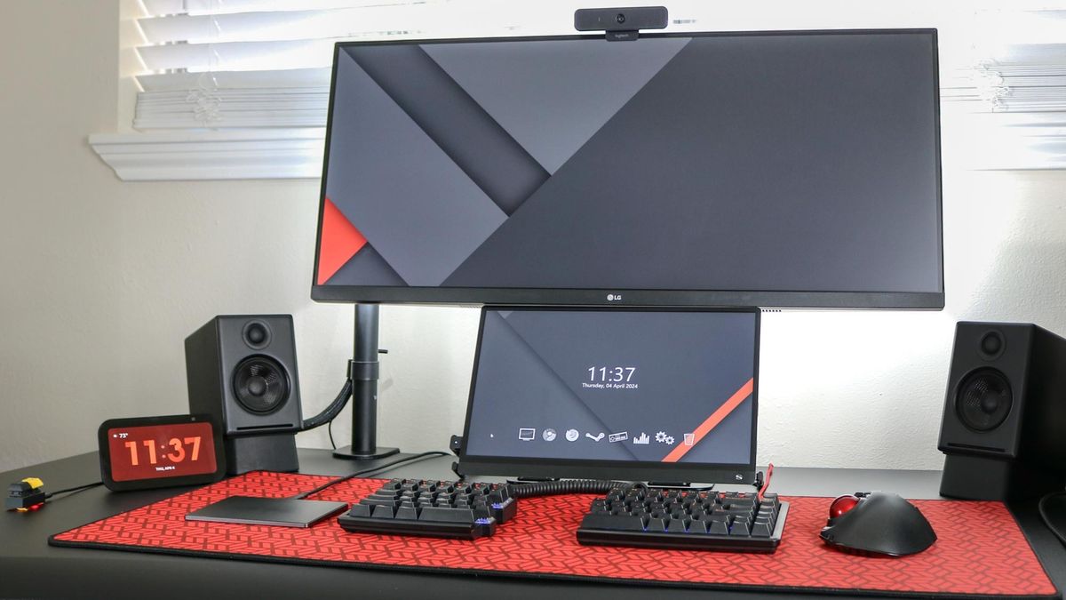 A picture of a desk setup with a trackpad on the left side of a split mechanical keyboard