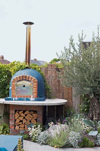 garden sleepers as cheap fence ideas behind pizza oven