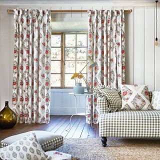 patterned floor length curtains in a panelled white living room with gingham sofa